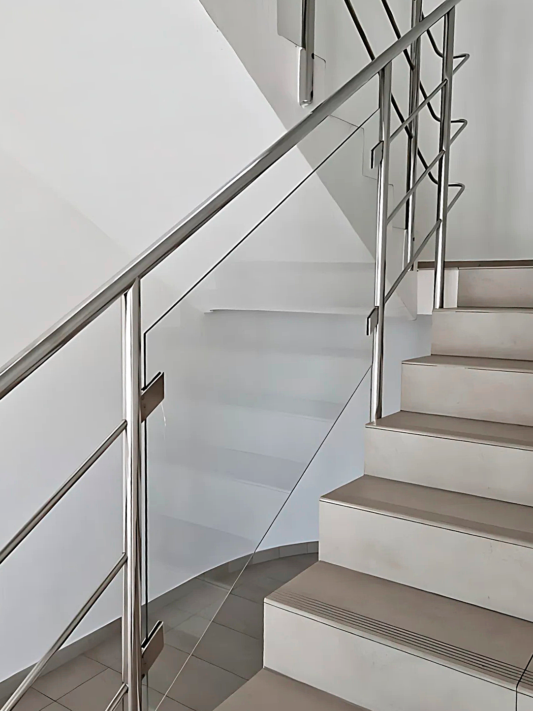 Barandal de vidrio templado con pasamanos inoxidable en escalera corporativa