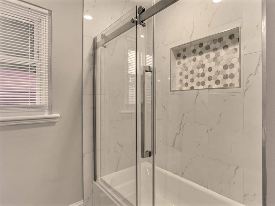 Cancel abatible de vidrio templado a piso completo en ducha principal, herrajes de acero inoxidable