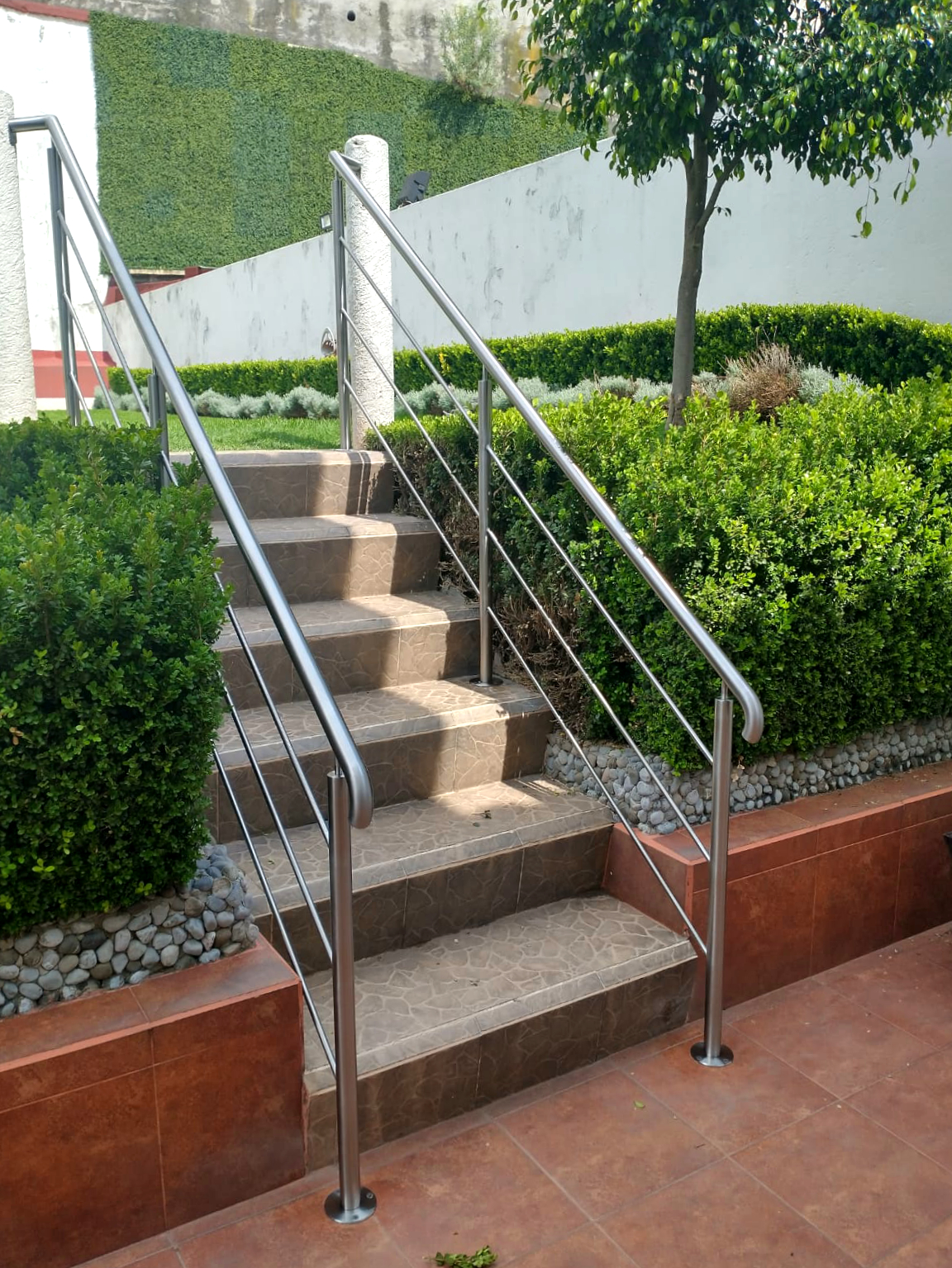 Escaleras de acceso a jardín con barandal de acero inoxidable