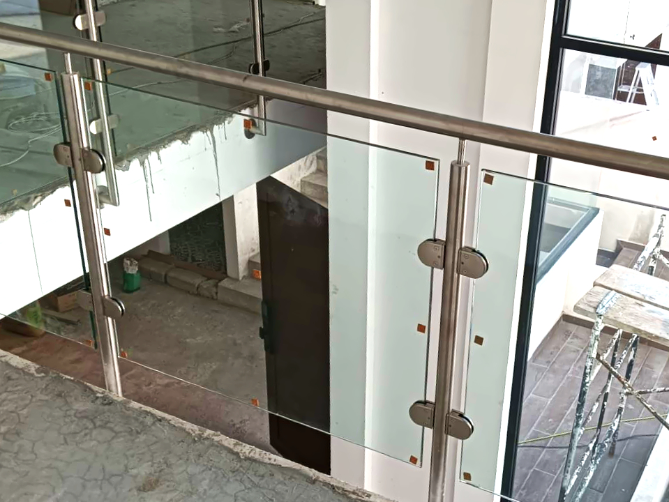 Vista lateral de barandal inoxidable en mezzanine de edificio, ejemplo de seguridad y plusvalía